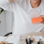 Costs - Woman at Desk Looking at Receipt and Scratching Her Head