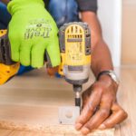 Power Tools - Person Using Dewalt Cordless Impact Driver on Brown Board