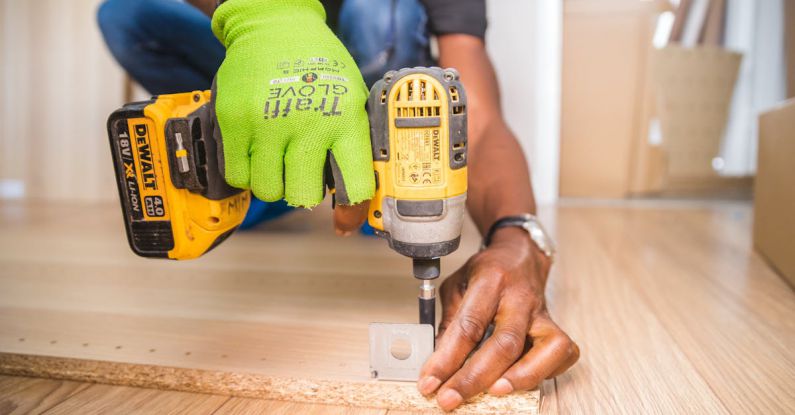Power Tools - Person Using Dewalt Cordless Impact Driver on Brown Board